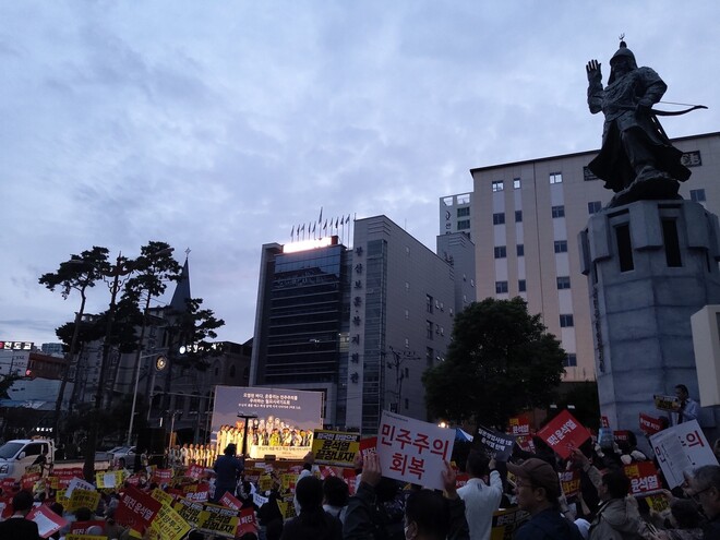 9일 부산 동구 초량동 일본영사관 앞 정발 장군 동상 앞에서 열린 시국기도회에서 참석자들이 노래를 부르며 손팻말을 흔들고 있다. 김광수 기자