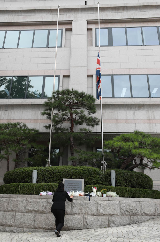 한 추모객이 13일 오후 조기가 게양된 서울 중구 정동 주한영국대사관 국기게양대 앞에 꽃을 놓고 있다. 김정효 기자