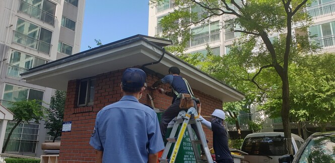 지난 25일 설비업체 직원들이 대전 대덕구 한 아파트 경비실에 미니태양광 시설을 설치하는 모습을 이 아파트 경비원이 바라보고 있다. 최예린 기자