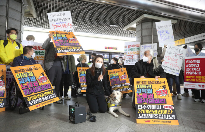 지난 28일 서울 경복궁역 3호선 승강장에서 열린 전국장애인차별철폐연대 회원들의 시위 장소에 참석한 국민의힘 김예지 의원이 자신의 안내견 조이와 함께 사과하며 무릎을 꿇고 있다. 신소영 기자 viator@hani.co.kr