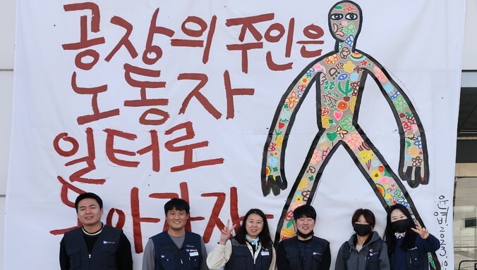 금속노조 한국옵티칼하이데크지회 조합원들이 2023년 11월13일 불 탄 구미공장 앞에 서 있다. 류우종 기자