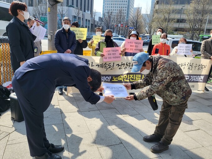 홈리스행동 회원이 윤석열 대통령 당선자 대통령직인수위원회 측에 ‘홈리스 의료접근성 강화를 위한 요구서한’을 전달하고 있다. 장현은 기자.