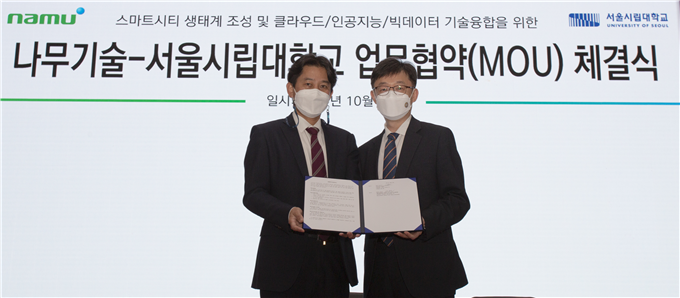 김홍준 나무기술 상무(왼쪽)와 염춘호 서울시립대학교 국제도시 및 인프라 연구센터장(오른쪽)이 2021 대한민국 도시재생산업박람회에서 MOU를 체결하고 기념촬영을 하고 있다. 서울시립대 제공