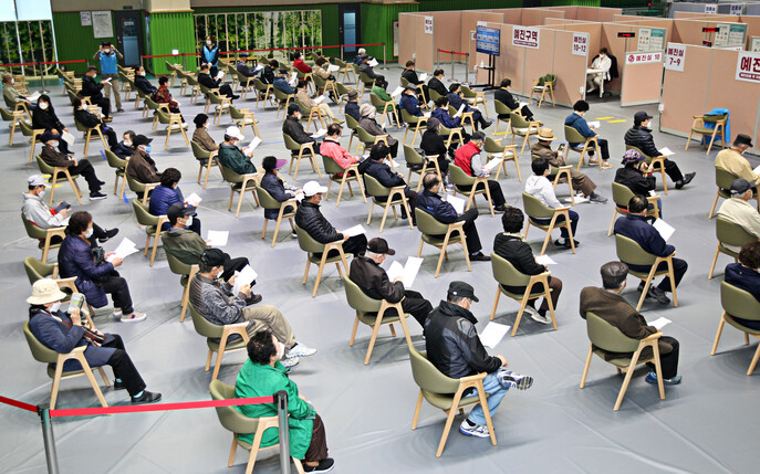 14일 서울 동작구 사당종합체육관에 마련된 코로나19 접종센터에서 어르신들이 예진실 앞에 앉아 화이자 백신 접종 순서를 기다리고 있다. 연합뉴스