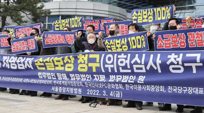 코로나 피해 자영업 총연합(코자총) 관계자들이 4일 오전 서울 서초구 서울행정법원 앞에서 기자회견을 열고 코로나 피해 자영업자 손실보상 청구 소장 접수에 앞서 손실보상을 촉구하며 구호를 외치고 있다. 연합뉴스
