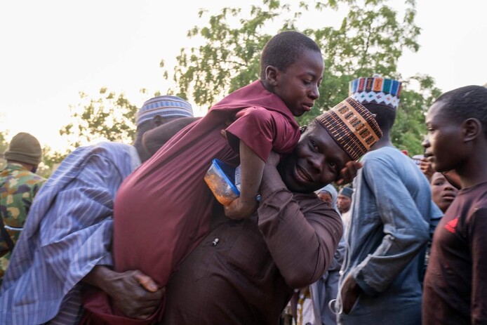 지난해 12월 나이지리아 카트치나주 칸카라의 한 중학교에서 무장 괴한들한테 납치됐던 학생들이 일주일 만인 18일 생환한 가운데, 한 남성이 살아 돌아온 아들을 들어 안으며 기뻐하고 있다. 카트치나/AFP 연합뉴스