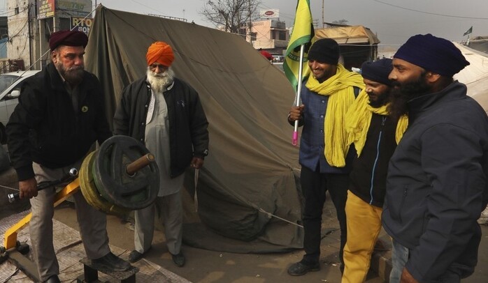 1일(현지시각) 인도 수도 뉴델리와 하리아나주 경계에서 농업법 개혁 반대 시위에 나선 농민들이 캠프의 체력단련 시설에서 운동을 하고 있다. AP 연합뉴스