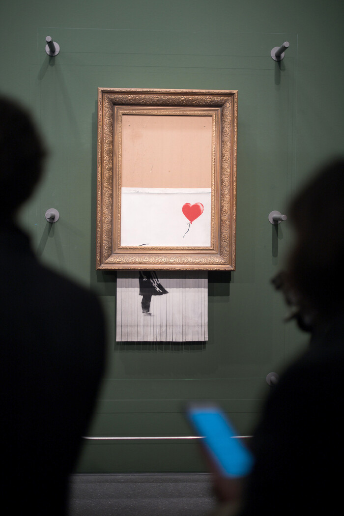 뱅크시의 작품 &lt;풍선과 소녀&gt;가 2018년 소더비 경매장에서 파쇄장치에 의해 잘려나간 뒤의 모습. 이후 뱅크시는 작품 이름을 &lt;사랑은 쓰레기통에&gt;로 바꾸었다. 미술문화 제공