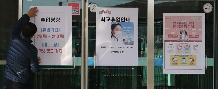 신종코로나바이러스 감영증 확진자가 거주하거나 이동·체류한 곳과 인접한 서울 성북구의 한 중학교 출입문에 학교 직원이 6일 휴업 명령 안내문을 부착하고 있다. 박종식 기자 anaki@hani.co.kr