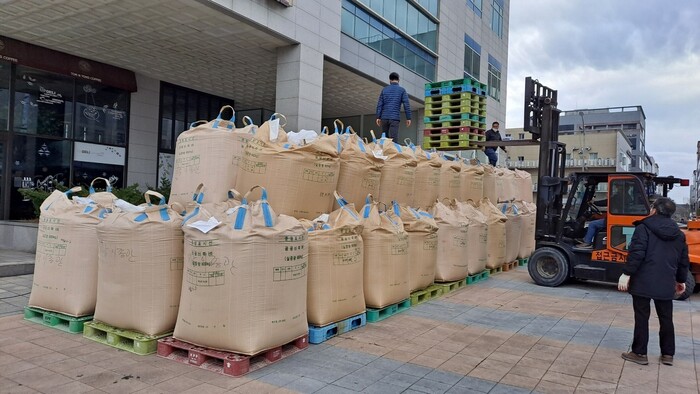 전남 농민들이 9일 전남 무안의 더불어민주당 전남도당 앞에서 지게차를 이용해 대형 볏가마(톤백) 60여개를 쌓고 있다. 전국농민회총연맹 광주전남연맹 제공