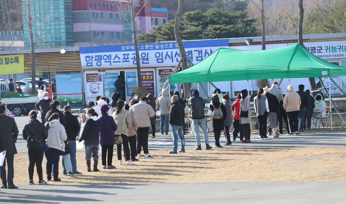 지난 13일 전남 함평엑스포공원 주차장에서 주민들이 진단검사를 받기 위해 길게 줄을 지어 서 있다. 연합뉴스