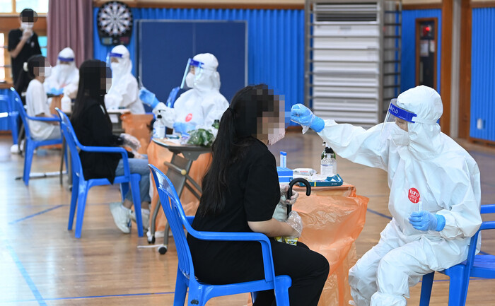7일 오전 광주 북구의 한 중학교에서 14명의 코로나19 확진자가 발생해 이 학교 1, 2학년 학생들이 전수검사를 받고 있다. 연합뉴스