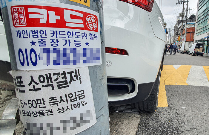 서울 용산의 한 골목 전봇대에 카드와 휴대전화 소액결제를 안내하는 안내문이 붙어 있는 모습. 연합뉴스