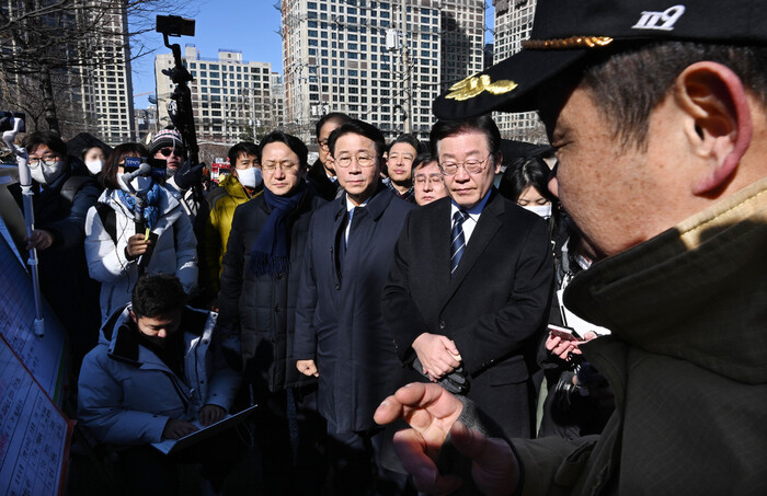 이재명 더불어민주당 대표가 20일 오전 화재가 발생한 서울 강남구 개포동 구룡마을 화재 현장을 방문해 소방당국의 설명을 듣고 있다. 사진 연합뉴스