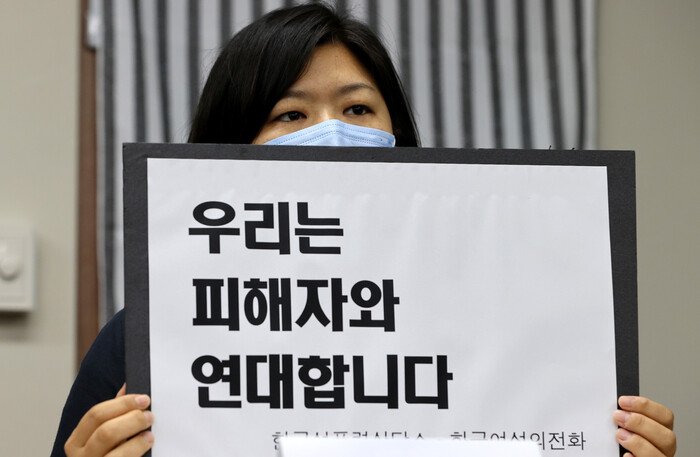 13일 오후 서울 은평구 녹번동 한국여성의전화 사무실에서 열린 ‘서울시장에 의한 위력 성추행 사건 기자회견’에서 피해 여성의 편지를 대독한 김혜정 한국성폭력상담소 부소장이 ‘우리는 피해자와 연대한다’는 내용의 손팻말을 들고 있다. 이정아 기자 leej@hani.co.kr