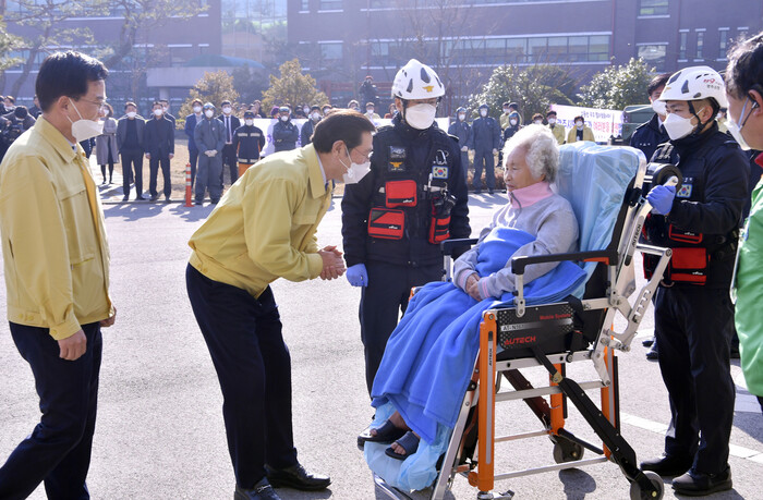 이용섭 광주광역시장이 20일 오전 코로나19 임시 격리시설인 광산구 소방학교 생활관을 방문해 격리 해제로 퇴소하는 환자들을 격려하고 있다. 광주시 제공