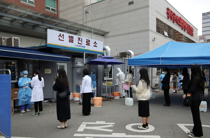 20일 오후 광주 동구 전남대학교병원에서 병원 의료진과 직원들이 코로나19 검사를 받기 위해 선별진료소 앞에 줄지어 있다. 전남대병원은 코로나19 확진자의 잇따른 발생으로 본관 병실을 동일 집단(코호트) 격리하고 외래와 응급실 진료를 중단했다. 연합뉴스