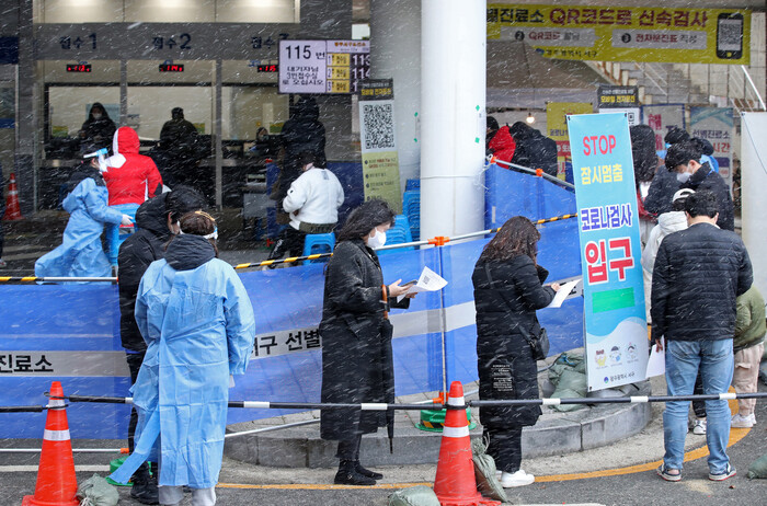 17일 오전 광주 서구보건소 선별진료소에서 코로나19 검사를 받으려는 시민들이 눈을 맞으며 줄 서 있다. 연합뉴스