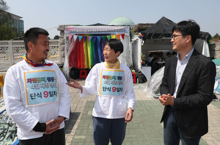 차별금지법 제정을 요구하며 국회 앞에서 단식농성 중인 종걸 차별금지법제정연대 공동대표(왼쪽)와 미류 차별금지법제정연대 집행위원(가운데)이 지난 19일 오후 김승섭 교수와 이야기를 나누고 있다. 윤운식 선임기자 yws@hani.co.kr