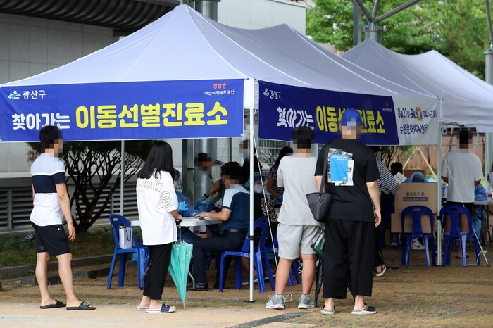 광주 광산구 수완문화체육센터 주차장에 마련된 이동 선별진료소에서 지난 21일 시민이 코로나19) 진단검사 차례를 기다리고 있다. 연합뉴스