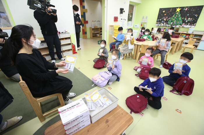 지난 2월22일 오전 서울의 한 유치원에서 어린이들이 배부받은 코로나19 자가진단키트를 들어 보이고 있다. 공동취재사진
