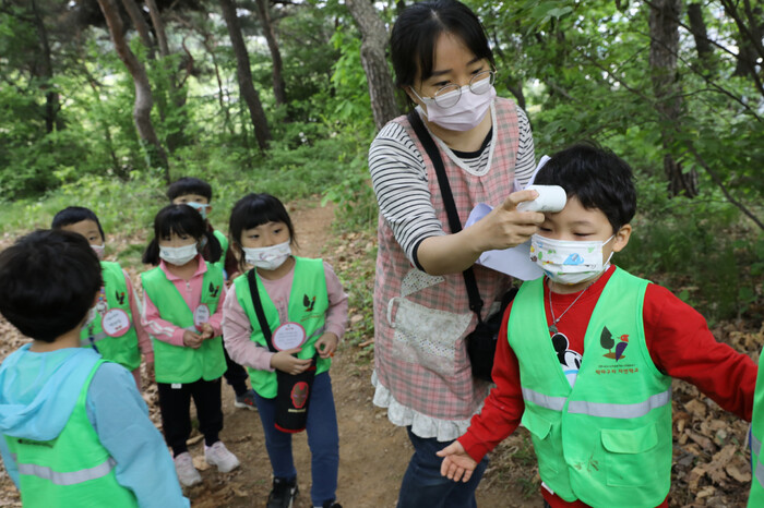 2021년 4월27일 인천 남동구 논현동 늘솔길 근린공원 유아숲체험원을 찾은 어린이들이 숲체험에 앞서 유치원 선생님에게 발열검사를 받고 있다. 류우종 기자 wjryu@hani.co.kr