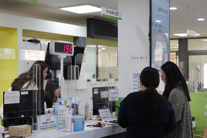 행정안전부가 전국 시군구·읍면동 주민센터에서 민원 서류 발급 서비스를 재가동한다고 알린 20일 오전 서울 종로구 청운효자동주민센터 창구에서 민원인들이 업무를 보고 있다. 연합뉴스