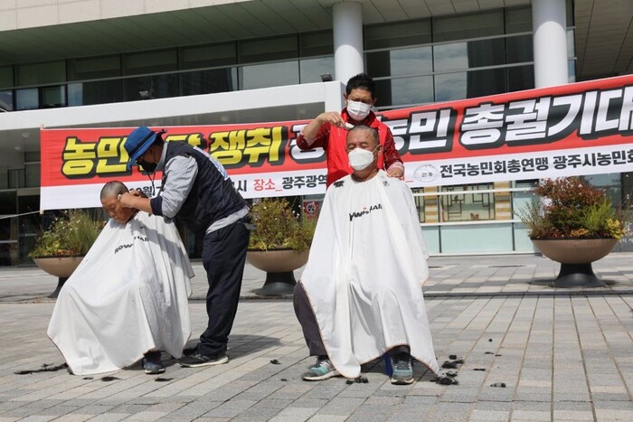 지난 7일 광주시의회 앞에서 전국농민회총연맹 광주시농민회 농민들이 농민수당 조례 제정을 촉구하며 머리를 깎고 있다. 광주시 농민회 제공