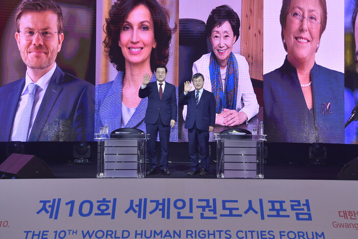 이용섭 광주광역시장이 7일 오후 광주 김대중컨벤션센터에서 실시간 온라인 화상으로 진행된 제10회 세계인권도시포럼에서 참석자들의 사진을 배경으로 기념사진을 찍고 있다. 광주시 제공