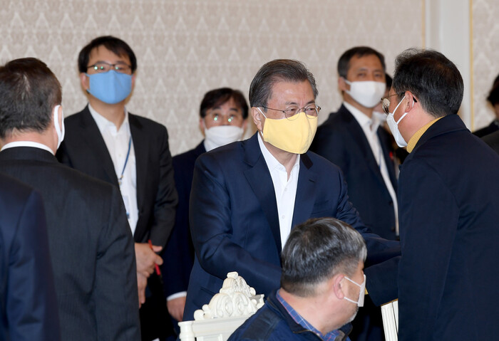 문재인 대통령이 18일 청와대에서 열린 코로나19 대응 논의를 위한 경제주체 원탁회의에 입장하면서 참석자들과 악수를 하고 있다. 청와대 사진기자단