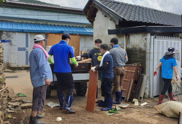 자원봉사자들이 지난해 8월 수해로 침수된 곡성의 한 주택에서 가재도구를 꺼내고 있다. 곡성군청 제공