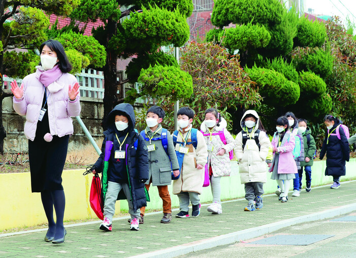 지난해에는 코로나19로 학부모 상담이 취소된 학교가 많았지만, 올해는 전화 또는 대면으로 새 학기 상담이 많이 진행되고 있다. 사진은 한 초등학교 신입생들이 입학식날 담임선생님을 따라 교실로 들어가는 모습. 부산/연합뉴스