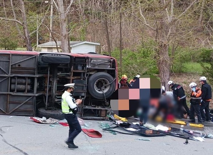 13일 오후 6시 5분께 충북 충주시 수안보면 온천리의 한 도로에서 버스가 전복됐다. 충북소방본부 제공, 연합뉴스