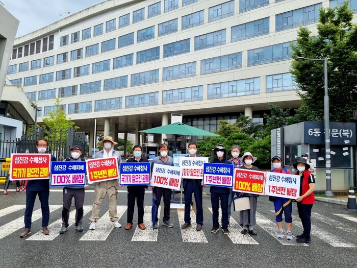 구례 주민을 대표한 신청인들이 2일 환경부 중앙환경분쟁조정위원회 앞에서 섬진강 범람 피해의 100% 배상을 신청하고 있다. 섬진강수해참사피해자 구례군비상대책위원회 제공