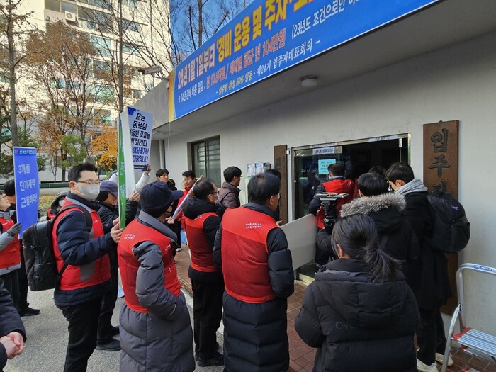 28일 민주노총 전국민주일반노동조합과 소속 경비원들이 경비원 감원을 저지하기 위해 대치 선경아파트 관리사무소로 들어가는 모습. 김채운 기자