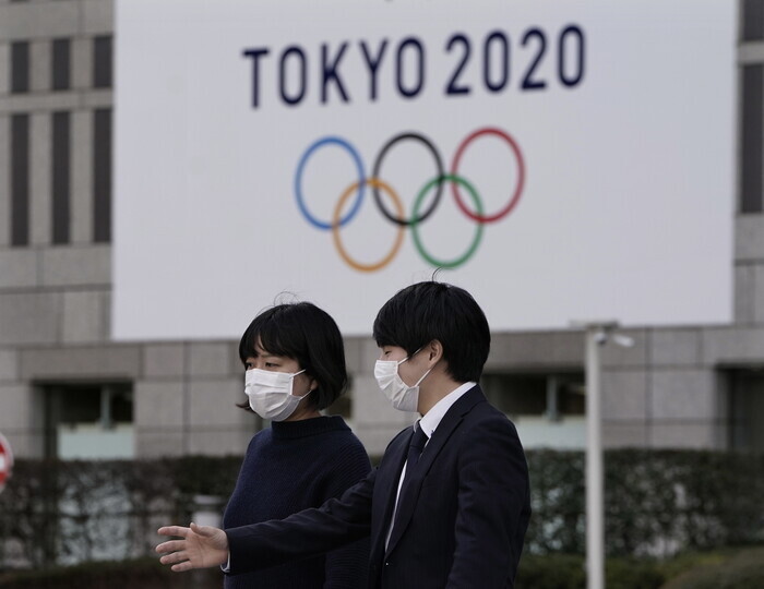 도쿄시청 벽에 걸린 2020 도쿄올림픽 걸개그림 앞으로 시민이 걸어가고 있다. 도쿄/EPA 연합뉴스