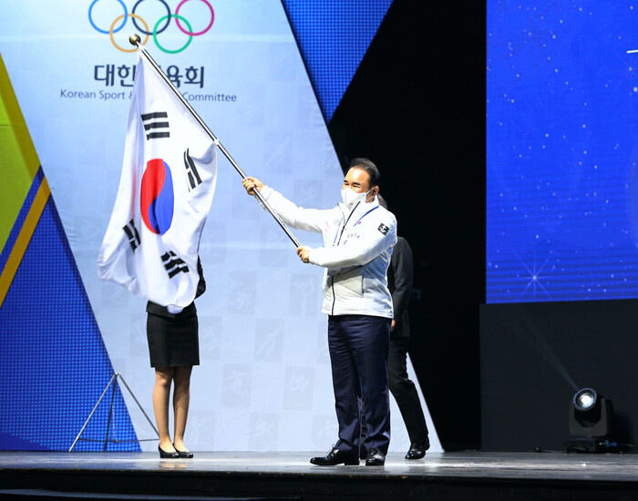 지난달 27일 열린 베이징 동계올림픽 선수단 결단식에서 윤홍근 제너시스 비비큐 회장(대한민국 선수단장)이 태극기를 흔들고 있다. BBQ 제공