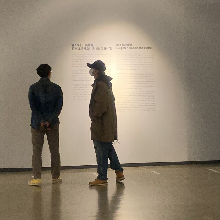 모자를 쓴 채 코트와 청바지 차림으로 전시장을 둘러보는 아르엠의 모습. 기획사 XCI 제공