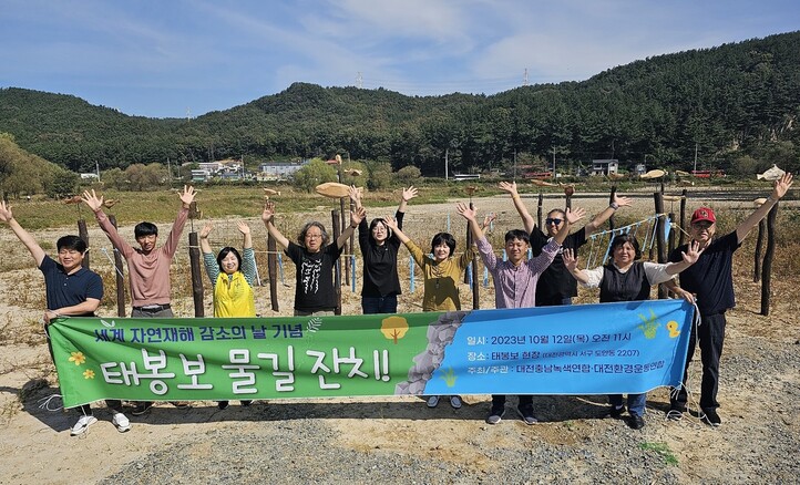 대전충남녹색연합과 대전환경운동연합 회원들이 지난 12일 해체된 태봉보 자리 근처에 솟대를 세운 뒤 기념사진을 찍고 있다. 최예린 기자