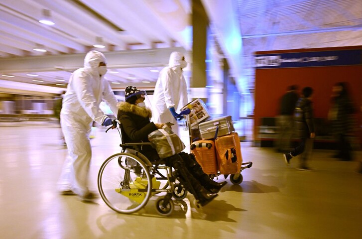 중국 여행객이 29일(현지시각) 이탈리아 로마 플루미시노 국제공항에서 보건요원들의 도움을 받아 휠체어를 타고 이동하고 있다. AFP 연합뉴스
