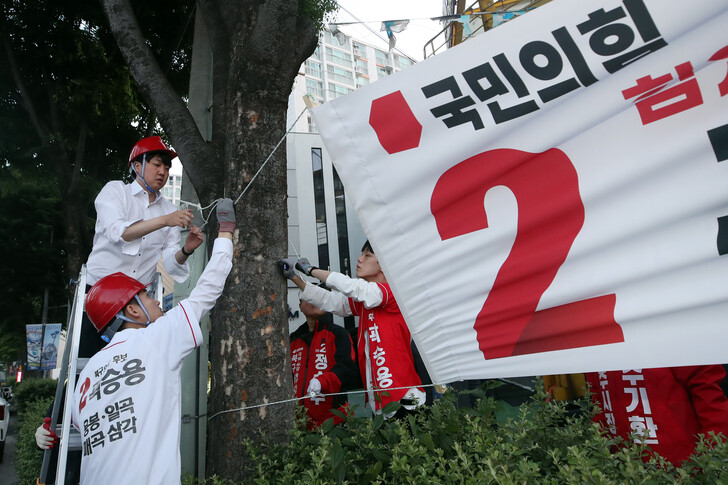 이준석 국민의힘 대표가 지난 21일 광주 북구 신안동 한 거리에서 누군가에 의해 훼손된 국민의힘 후보 현수막을 다시 걸고 있다. 광주/연합뉴스