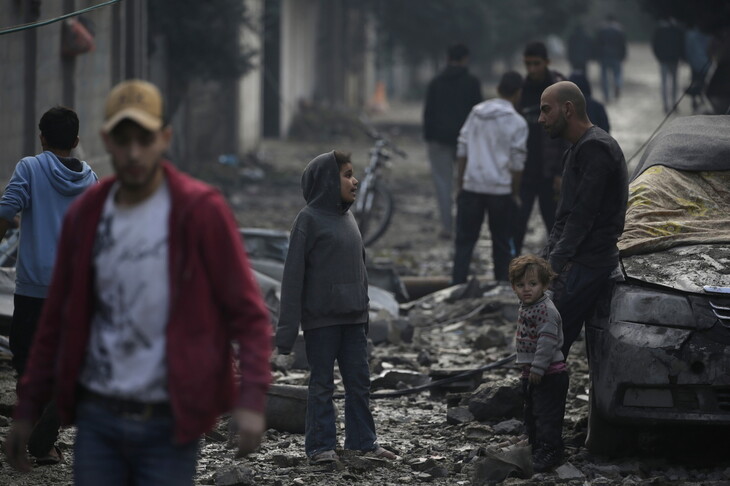 성탄절인 25일(현지시각) 이스라엘군의 대규모 폭격으로 건물들이 무너져 내린 팔레스타인 가자지구에서 한 아버지가 아이들과 함께 서 있다. 가자지구/EPA 연합뉴스