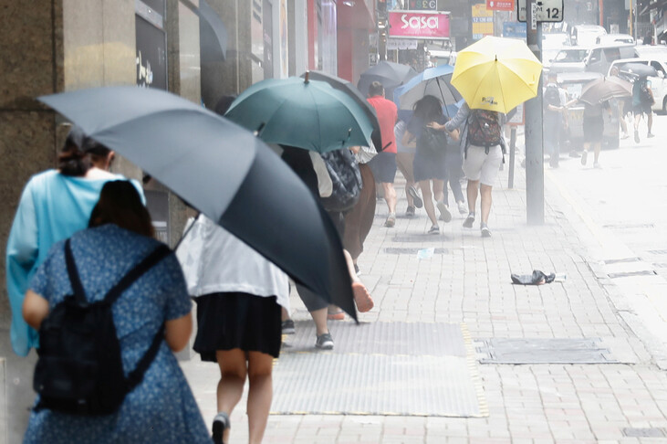 홍콩 시민들이 27일 시위 진압 경찰이 쏜 고추 스프레이를 우산으로 막으며 달리고 있다. 홍콩/로이터 연합뉴스
