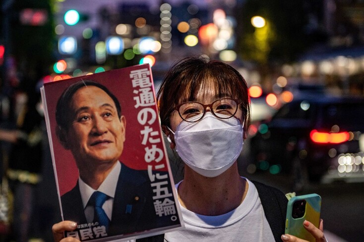 도쿄 올림픽 개최에 반대하는 일본 시위대가 스가 요시히데 총리의 초상화를 들고 있다. 도쿄/AFP 연합뉴스