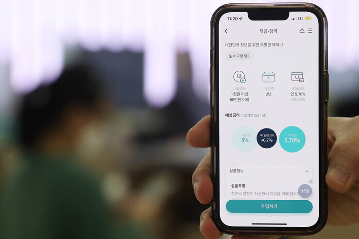 지난 21일 출시된 '청년희망적금’에 20·30 청년들의 관심이 쏠리고 있다. 희망적금은 지난 21일부터 국민·신한·하나·우리·농협·기업·부산·대구·광주·전북·제주은행 등 11개 은행에서 대면·비대면 방식으로 판매 중이다. 사진은 이날 서울의 한 은행과 모바일 앱. 연합뉴스