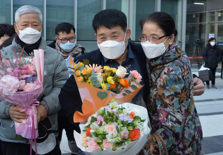 ④12월17일 오후 경기도 수원시 영통구 수원지방법원에서 열린 이춘재 연쇄살인 8차 사건 재심 선고공판에서 재심 청구인 윤성여씨가 무죄를 선고받고 법원 청사를 나와 지인들의 축하를 받고있다. 사진공동취재단