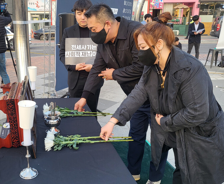 18일 인천 미추홀구 주안역 남광장에서 전세사기·깡통전세 피해자 전국대책위원회 소속 회원들이 전세사기를 당한 뒤 극단적 선택을 한 피해자 세 명의 사진 앞에 헌화하고 있다. 이승욱 기자