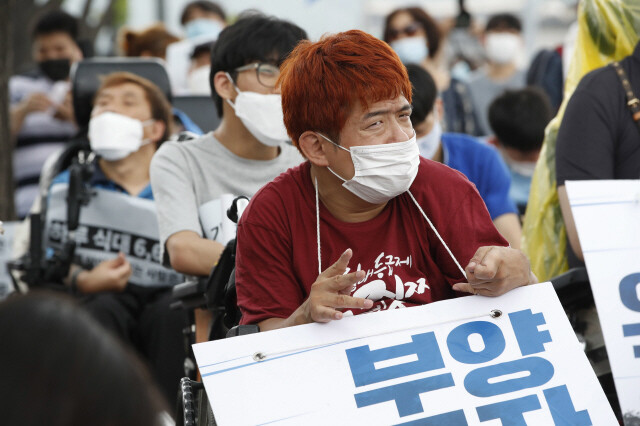 제60차 중앙생활보장위원회가 열리고 있는 지난해 7월31일 오후 정부서울청사 앞에서 ‘장애인과 가난한 사람들의 민중생활보장위원회 기자회견’이 열려 참가자들이 정부에 의료급여 항목 등을 포함한 부양의무자 기준 완전 폐지 등을 촉구하는 구호를 외치고 있다. 이정아 기자 leej@hani.co.kr