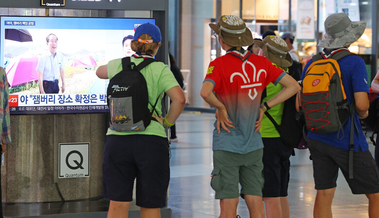 새만금 세계 스카우트 잼버리에서 조기 퇴영한 영국 스카우트 대원들이 6일 서울 용산역에서 잼버리 관련 뉴스를 바라보고 있다. 연합뉴스