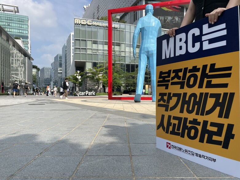 전국언론노동조합 방송작가지부가 18일 오전 서울 마포구 상암동 &lt;문화방송&gt;(MBC) 사옥 앞에서 이달 초 복직한 방송작가 두명과 관련한 복직 협상 등을 요구하며 1인 시위를 벌이고 있다. 방송작가유니온 제공